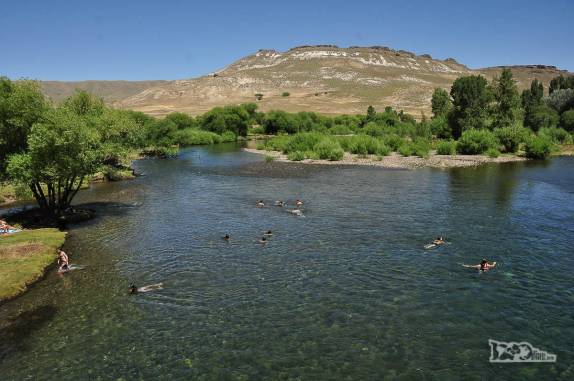 Pessoas nadam no delicioso rio de águas limpas e transparentes que corta a cidade de Junín de Los Andes, na Argentina